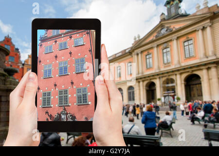 travel concept - tourist photographs facade of old historical house on stortorget square near swedish academy in stockholm on ta Stock Photo