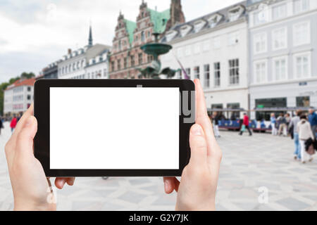 travel concept - tourist photographs Amagertorv the most central square in Copenhagen, Denmark on tablet pc with cut out screen Stock Photo