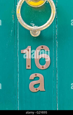 Light blue English period wooden front door with ornate iron door knocker. House number position under door knocker. Soft natura Stock Photo