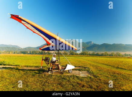 Motor hang glider close up on the ground and man.