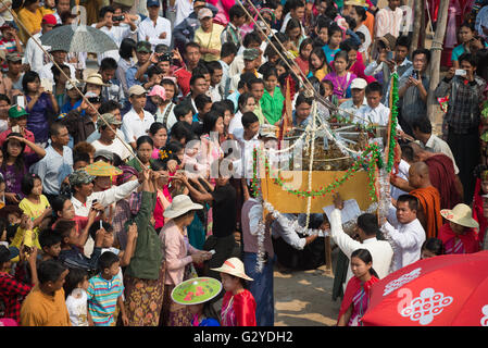 Crowd surrounding a vessel with the zedji (golden umbrella) during inauguration of a new pagoda, Demoso, Kayah State, Myanmar Stock Photo