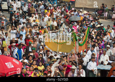 Crowd surrounding a vessel with the zedji (golden umbrella) during inauguration of a new pagoda, Demoso, Kayah State, Myanmar Stock Photo