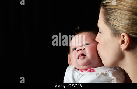 Mother kissing her newborn baby girl Stock Photo