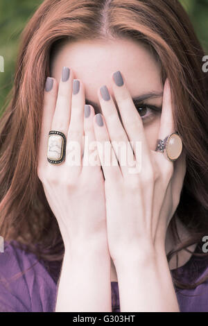 Young woman covering her face with her hands Stock Photo