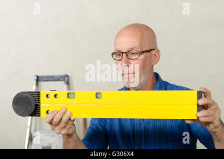 a mature man with a yellow spirit level Stock Photo