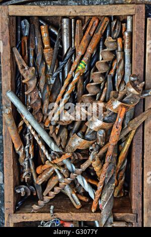 A old wooden box, full with old tools and drills. Old drill bits in an old tool box. Stock Photo