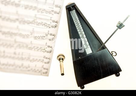 Metronome and mouthpiece of a trumpet isolated on a blank white background  as copy space Stock Photo