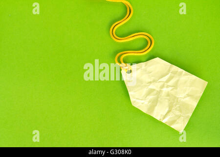Blank yellow price tag isolated on green, Price tag, gift tag, sale tag, address label, etc. Stock Photo