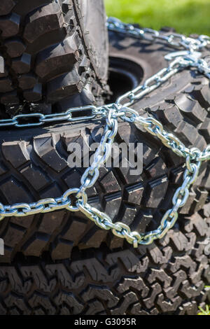 Close up shot of some chains wrapped around a car's tire. Stock Photo