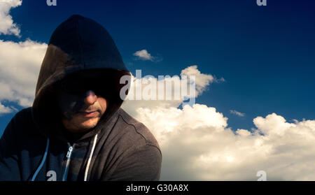 Single masked computer hacker thief with a cloud background for internet security based concepts. Stock Photo