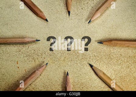 Three question marks surrounded with pencils on grunge background Stock Photo