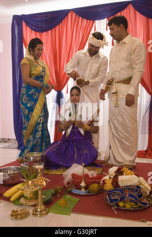 Hindu family in London UK celebrate their 16 year old daughters coming of age party. Ritushuddhi,  also called as Ritu Kala Samskara, Coconut milk is poured onto her head by her brother. It  symbolises health and prosperity, family members stand by her side. Mitcham south London. A celebration and the transition to womanhood.   2010s 2016 UK  HOMER SYKES Stock Photo