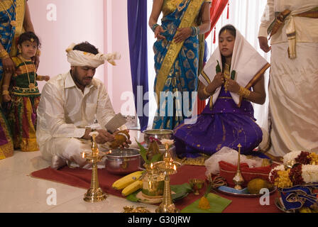 Hindu family in London celebrate their 16 year old daughters coming of age party. Ritushuddhi,  also called as Ritu Kala Samskara,   Coconut milk is poured onto her head by her brother. It  symbolises health and prosperity, family members stand by her side. Mitcham south London.  A celebration and the transition to womanhood.   2010s 2016 UK  HOMER SYKES Stock Photo