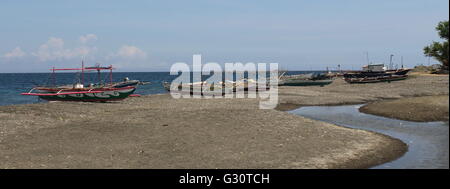 Indigenous double outrigger fishing boats in a coastal village in the Philippines Stock Photo