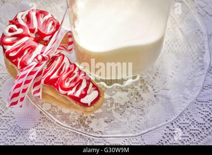 Cookies And Milk For Santa. Red and white Christmas sugar cookies and  milk for Santa. Stock Photo