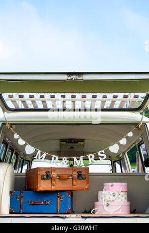 Vintage wedding VW Campervan with a Mr and Mrs decoration and luggage in the rear at a vw show. Oxfordshire, England Stock Photo