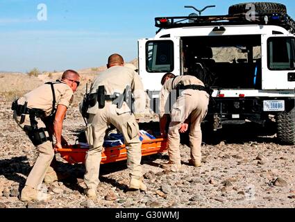 U.S Border Patrol agents load an illegal migrant into a rescue vehicle during training for assisting and recovering migrants suffering from extreme temperatures in the desert June 3, 2016 near Yuma, Arizona. Stock Photo