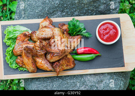 Grilled chicken wings in nature on a rock Stock Photo