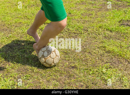 Amateur soccer on old and bad field with shabby ball and barefoot Stock Photo