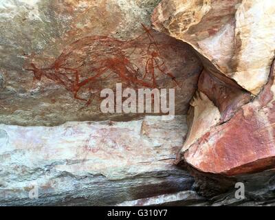 A rock wallaby with human figures painted in a cave at 'The Castle' at Gubara in Kakadu National Park, Australia. Stock Photo