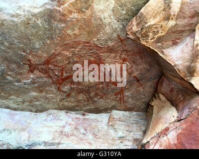 A rock wallaby with human figures painted in a cave at 'The Castle' at Gubara in Kakadu National Park, Australia. Stock Photo