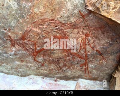 A rock wallaby with human figures painted in a cave at 'The Castle' at Gubara in Kakadu National Park, Australia. Stock Photo