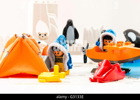 Lego duplo explore Arctic toy playset. Two lego characters, man and woman, in base camp, with plane, polar bear, icebergs and penguins behind. Stock Photo