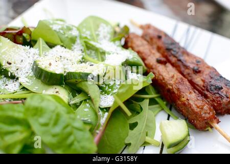 Kebab sticks served with a green salad Stock Photo