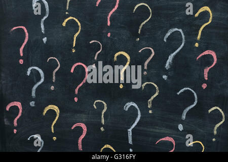 Colorful question marks on chalkboard background. Close up. Stock Photo