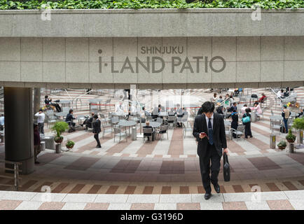 Japanese Businessman walks through I-Land Building Patio, Shinjuku, Tokyo, Japan Stock Photo