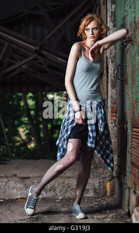 Portrait of a lovely young grunge girl in checkered shirt and torn pantyhose Stock Photo