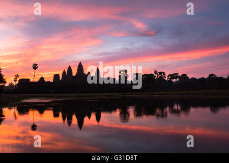 Angkor Wat temple at dramatic sunrise reflecting in water Stock Photo