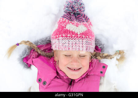 little girl happily playing in the snow Stock Photo