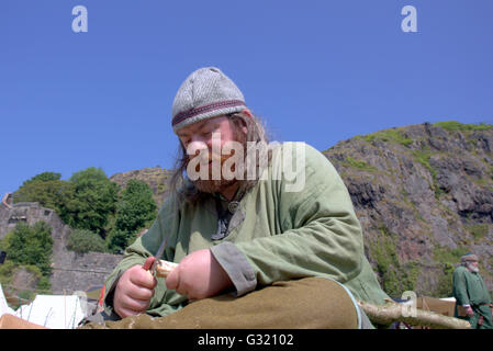 Glasgow, Scotland, UK  5th June 2016. UK weather Glasgow scorches, 'The Rock Of Ages' a Historic Scotland event in Dumbarton castle  today. A historical reenactment extravaganza  of the two thousand years of military history connected to the rock.Viking en-actor carves useful implements from foraged wood under the blistering sun © Gerard Ferry/Alamy Live News Stock Photo