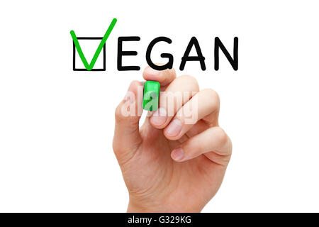 Hand putting check mark with green marker on the tick box in Vegan survey form. Stock Photo