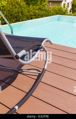 a chaise lounge on the pool side made of wooden planks Stock Photo - Alamy