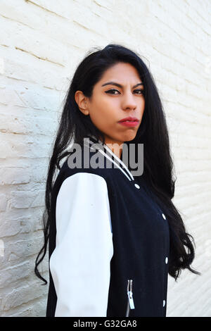 Portrait of young latin woman outdoors. Trendy and urban clothes. Stock Photo