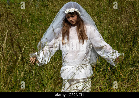 6- 7 year old girl dressed in white veil, girls games, age of innocence, child bride Stock Photo