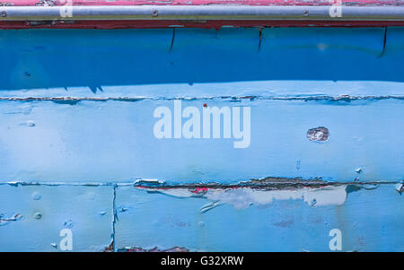 a detail image of an old wooden boat with peeling paint and signs of being exposed to the elements for years Stock Photo
