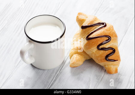 Fresh croissants and milk on wooden table Stock Photo