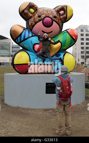 Berlin, Germany, Woman doing in front of a colorful Baerenskulptur a caper Stock Photo