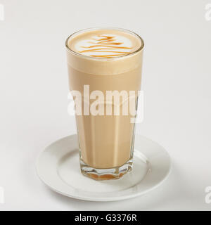 Delicious latte in a tall glass on the plate on white background. Close up side view. Stock Photo