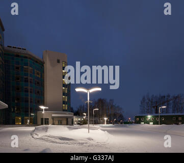 Street lamps of the office complex. Lighting supports and lamps. Winter, snow, evening. Stock Photo