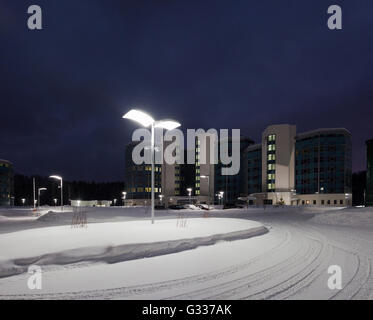 Street lamps of the office complex. Lighting supports and lamps. Winter, snow, evening. Stock Photo