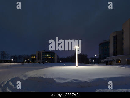 Street lamps of the office complex. Lighting supports and lamps. Winter, snow, evening. Stock Photo