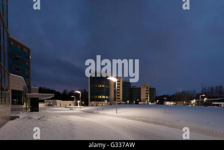 Street lamps of the office complex. Lighting supports and lamps. Winter, snow, evening. Stock Photo