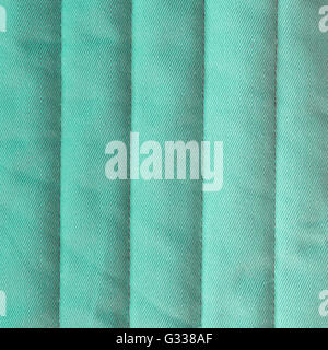 Pastel turquoise quilted textiles with insulation. Vertical stripes.  Close up fragment of the top view. Stock Photo