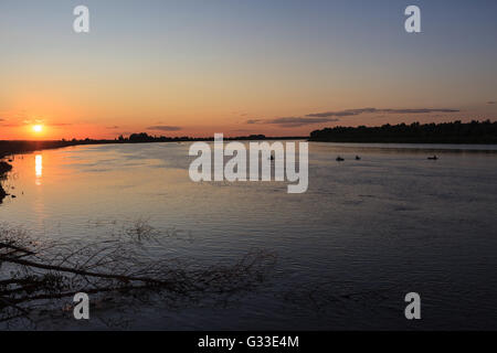 Evening vivid color sunset on the Volga river. Fishermen in boats. Stock Photo