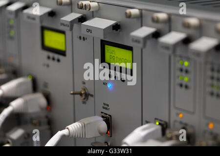 Front panel of industrial computer system with I/O ethernet connectors and cables. Selective focus on primary CPU module. Stock Photo
