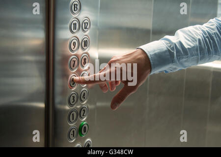 Pressing the button in the elevator Stock Photo